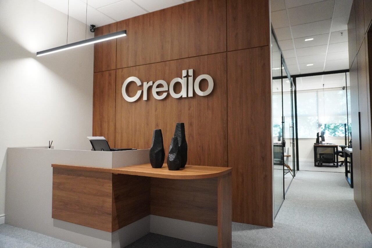 Sala de reunião do escritório Credio com TV e iluminação quente